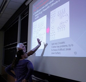 Instructor and student looking at projected images of two different model diagrams
