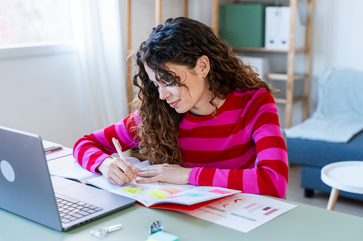 Woman organizing tasks using sticky notes and planner